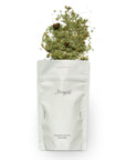 White bag with green herbs on a white background