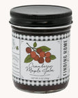 Jar of cranberry maple jam with a label on a white background