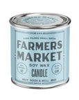 A cylindrical metal tin candle with a light blue label reading 'FARMERS MARKET' and 'SOY WAX CANDLE' on a plain white background.