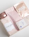 PINK PAMPER gift box in creme feating pink luxe socks, sparkling rose tin candle, mango sorbet body polish, pearl sheet mask, and a milk chocolate bar