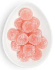 Oval dish filled with pink round gummies covered in sugar