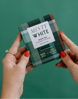 Person holding a box of 'Minty White' white tea against a green background