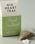 House-shaped tea box in green with a tea sachet outside and to the right of the box.