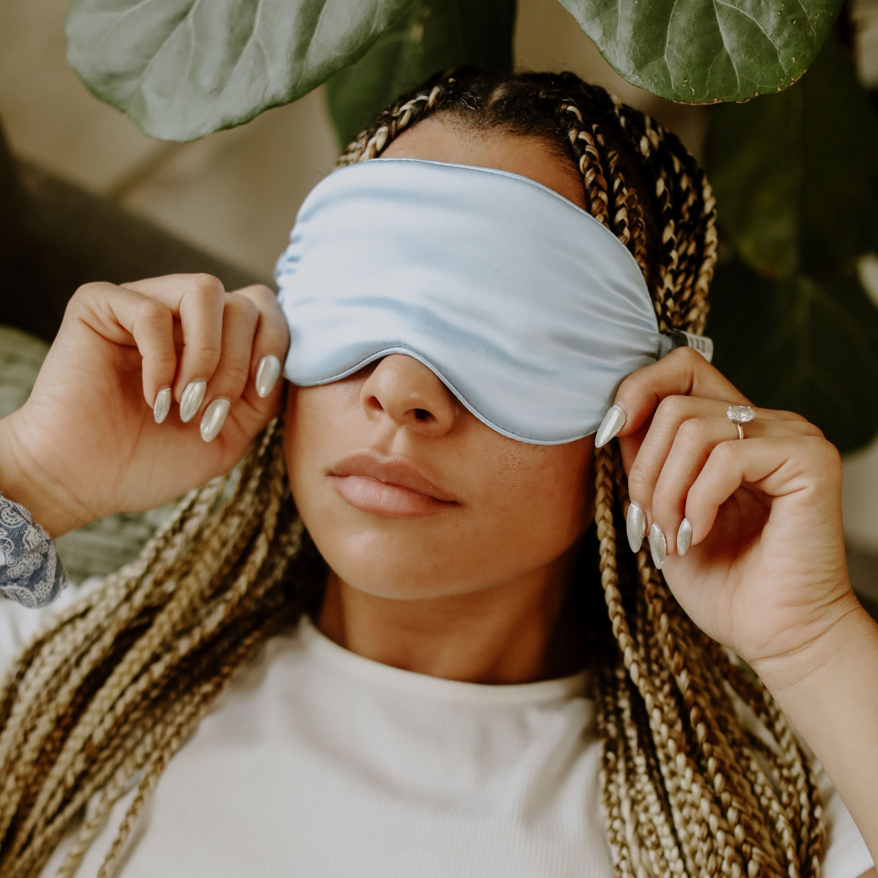 Girl with brunette and blonde braids wearing a blue silk sleep mask