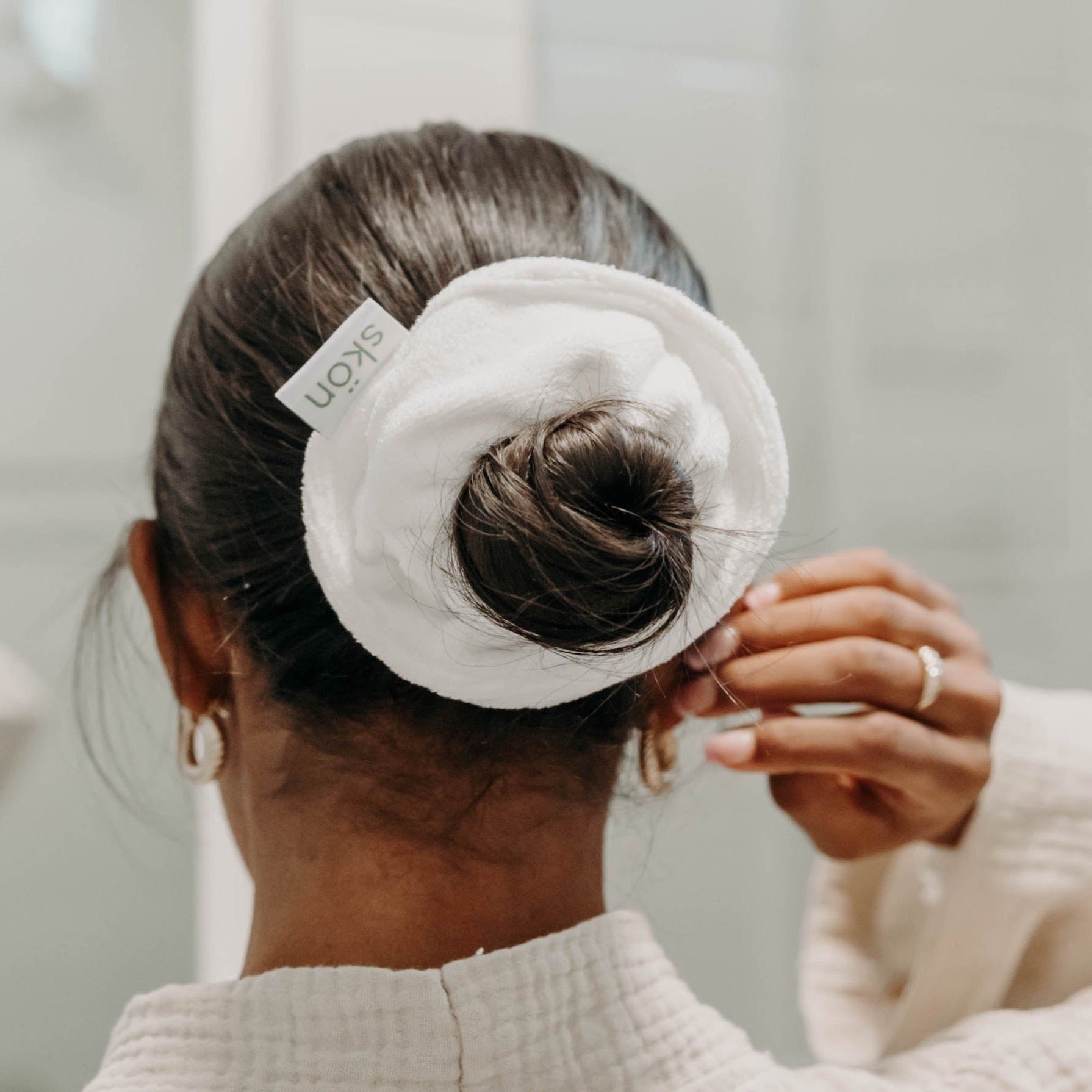 A woman with her hair tied up in a bun wearing the Skön Twist Me Up | Microfiber Hair Scrunchie.