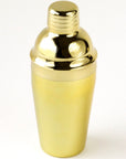 A gold cocktail shaker sitting on a white background.