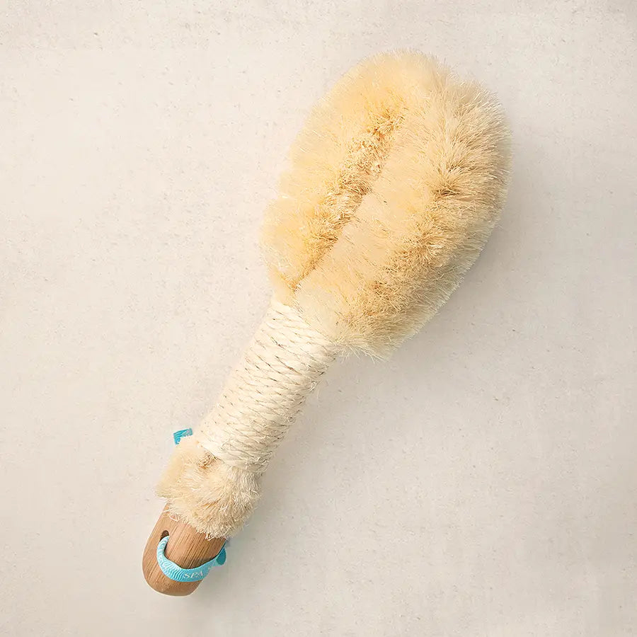 Beige bristle brush with wooden handle on a light gray background
