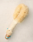 Beige bristle brush with wooden handle on a light gray background