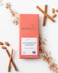 Moonstruck milk chocolate cinnamon bar with cinnamon sticks and ground cinnamon on a white background
