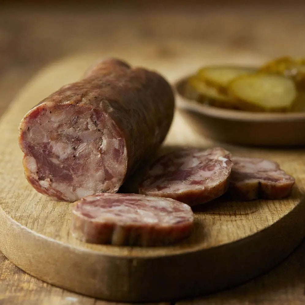 Salami with slices on a wooden board, blurred background