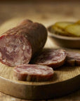 Salami with slices on a wooden board, blurred background