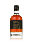 A bottle of Scotch whisky shown from the back, featuring a black label with gold text and a black screw cap, set against a plain white background with a soft reflection.