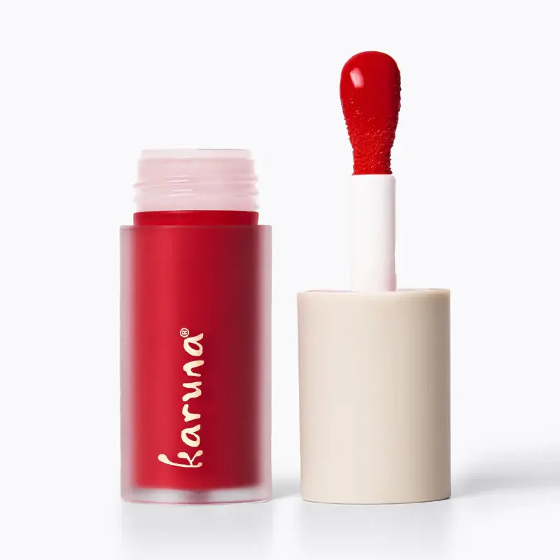 Red lipstick with applicator on a white background, featuring the brand 'karuna'.