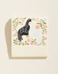 Card with two chickens in a floral wreath on a beige background