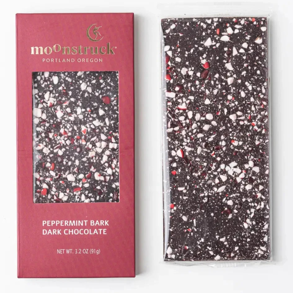 Peppermint Bark Dark Chocolate" bar from Moonstruck, with a maroon packaging design. The bar itself has a speckled look with pieces of white and red peppermint on dark chocolate