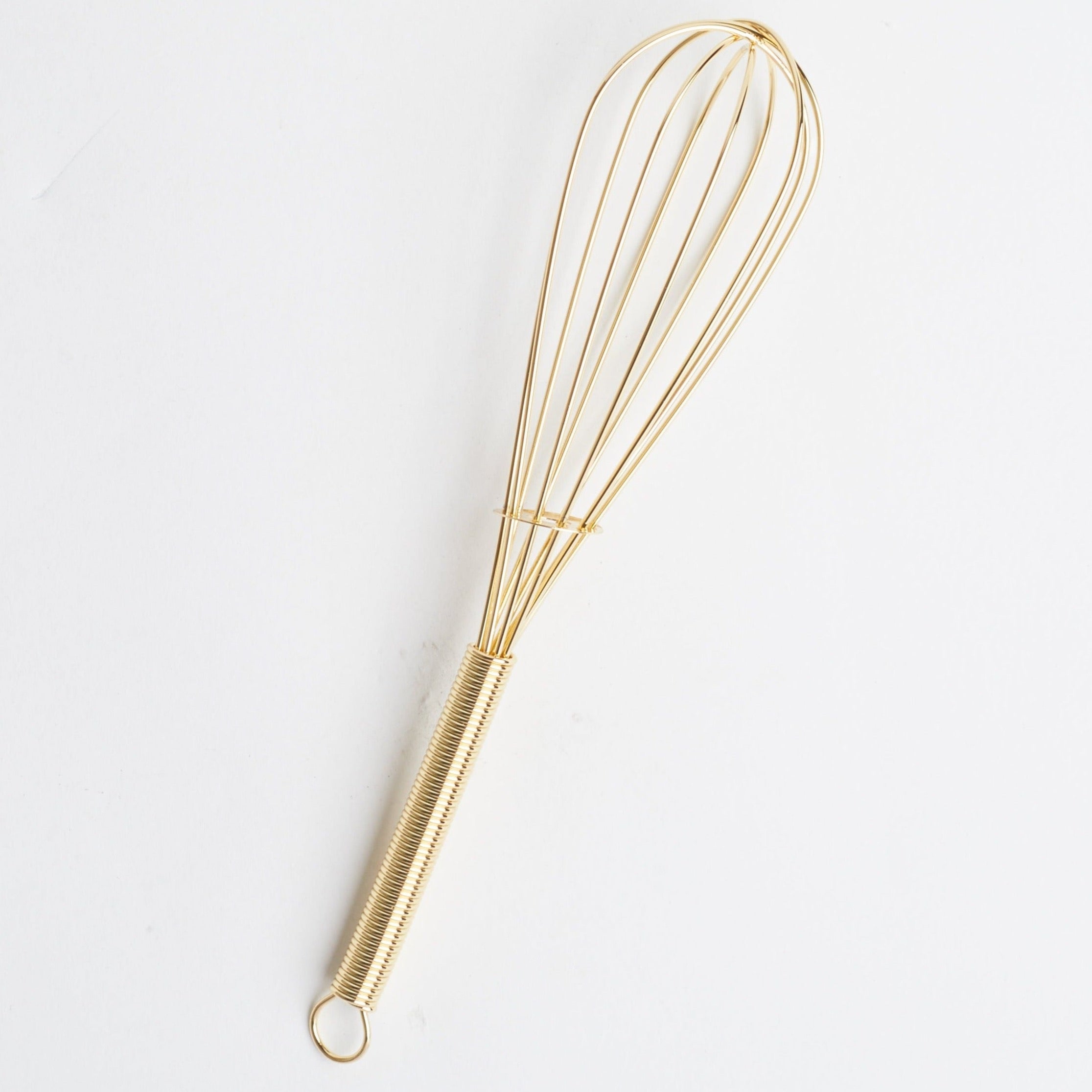 An 8" gold metal whisk against a white background