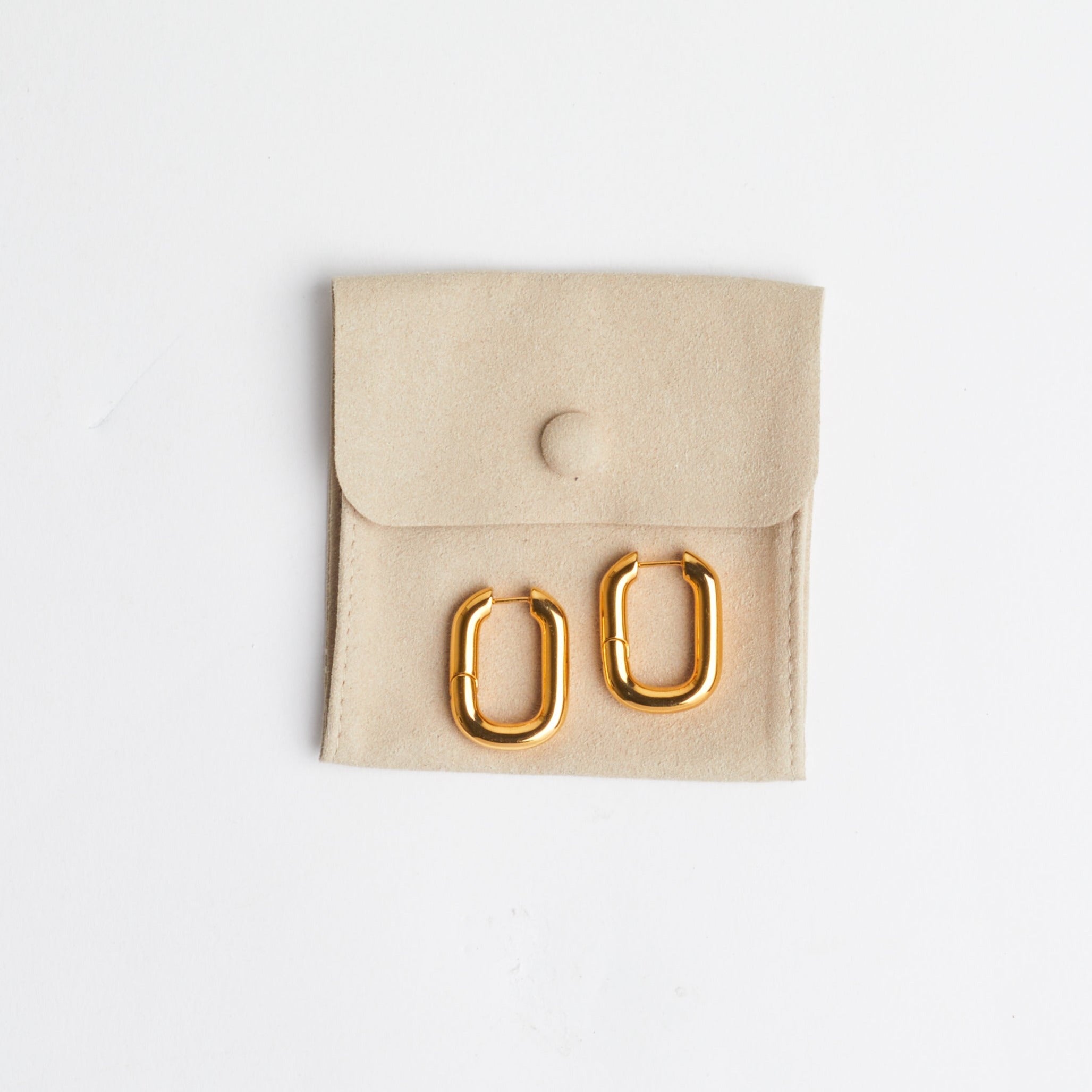 The Taryn | Gold Rectangular Hoop Earrings on tan suede jewelry bag