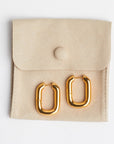 The Taryn | Gold Rectangular Hoop Earrings on tan suede jewelry bag