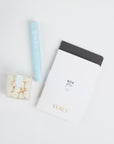 Sugarfina Champagne Bubbles, BOXFOX x Appointed Co. VOW Notebooks and Mine Co Ring Cleaning Pen laid out on white background