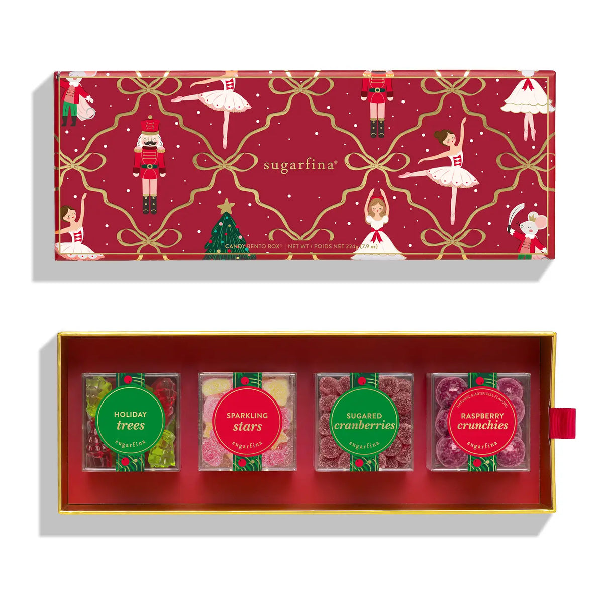 Sugarfina Christmas-themed gummy candy gift set in an open gold-trimmed red box, with the matching lid shown above. The lid features a festive red pattern with ballerinas, nutcrackers, gold ribbons, and a Christmas tree.