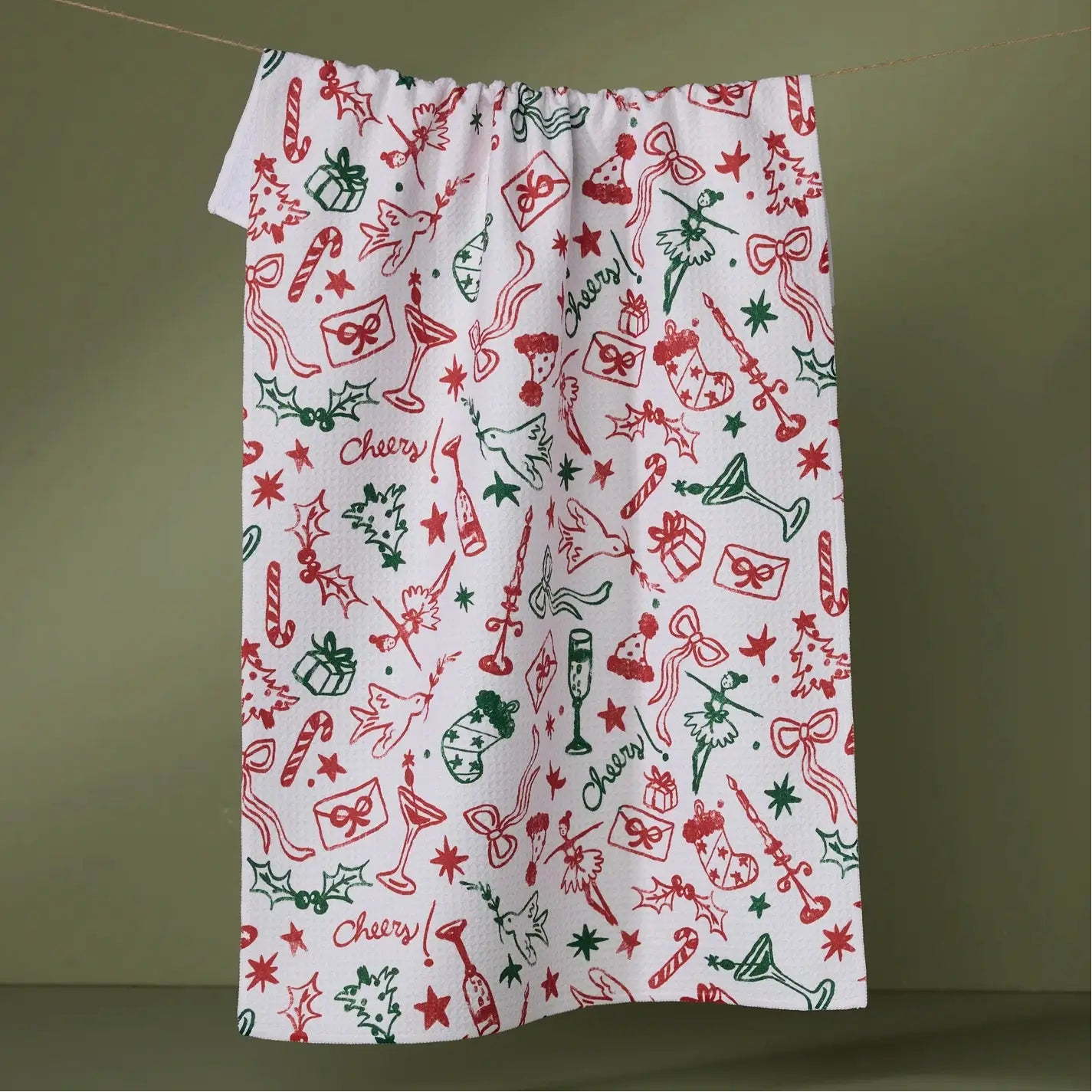 white tea towel with red and green holiday designs 