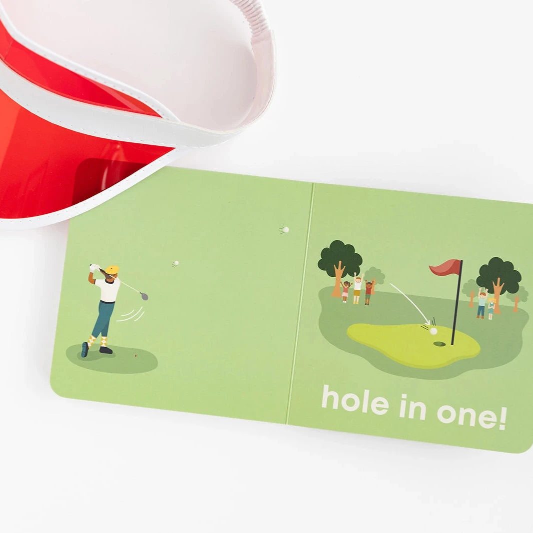 open golf baby book next to red visor