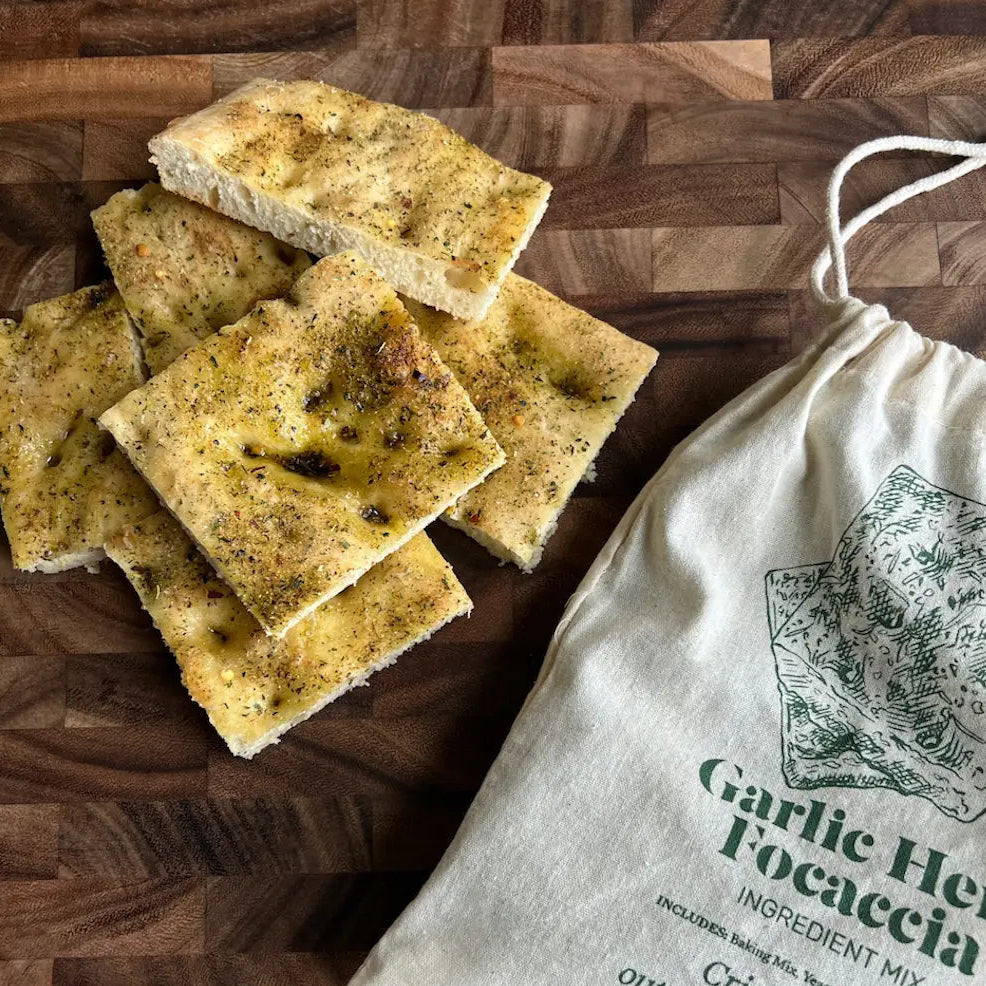 focaccia bread next to a white drawstring bag 