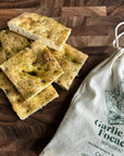 focaccia bread next to a white drawstring bag 