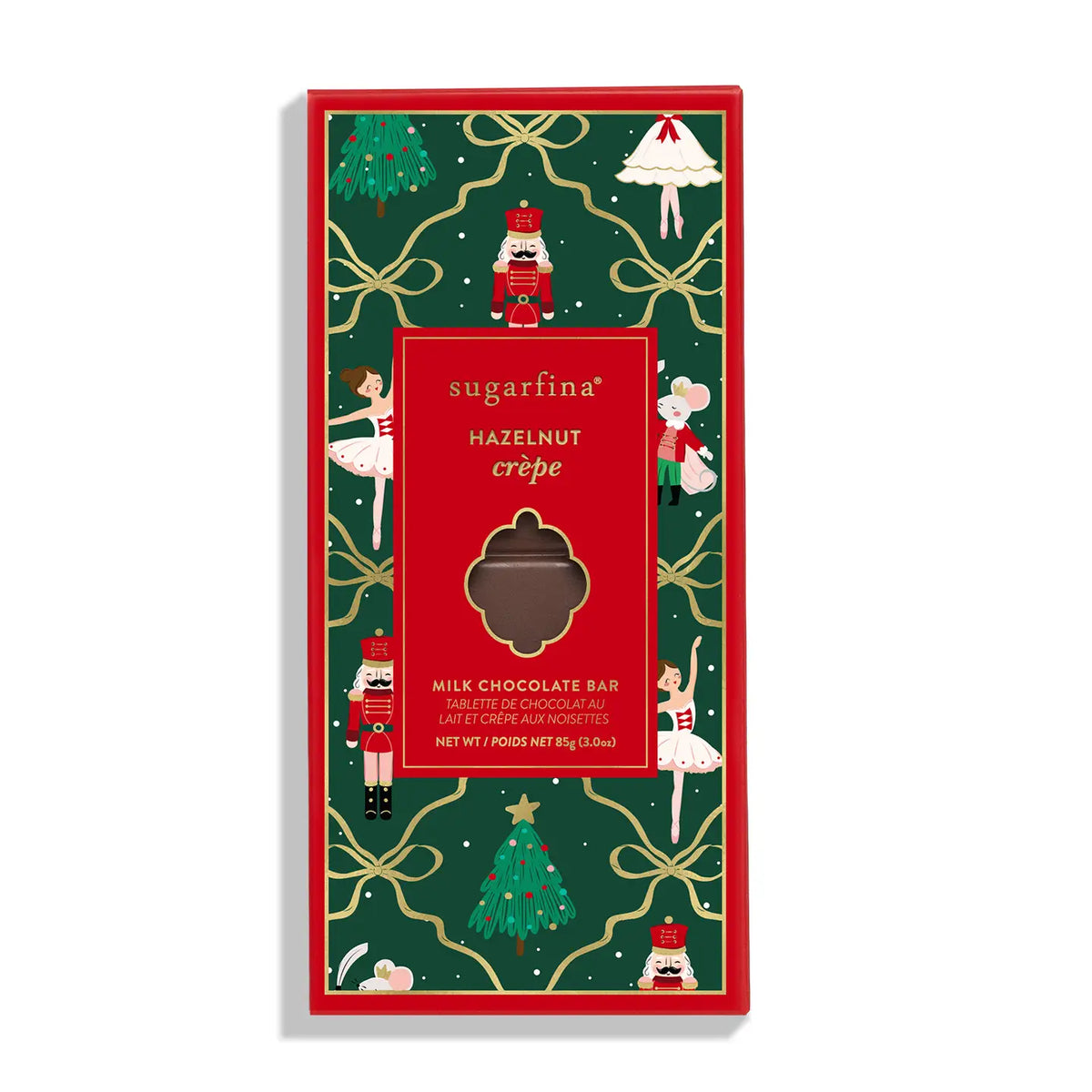 A packaged hazelnut crèpe milk chocolate bar in a festive Christmas-themed box by sugartina. The box features a dark green background decorated with gold bows, nutcrackers, Santa Claus figures, and Christmas trees, surrounding a central red label with a clear window showing the chocolate piece inside.