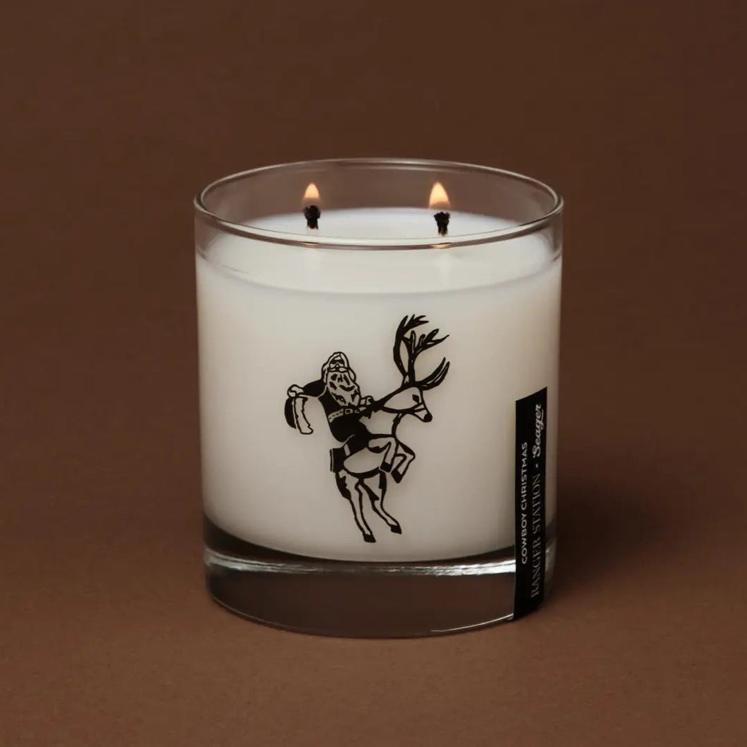 white candle with a cowboy and horse on a brown background