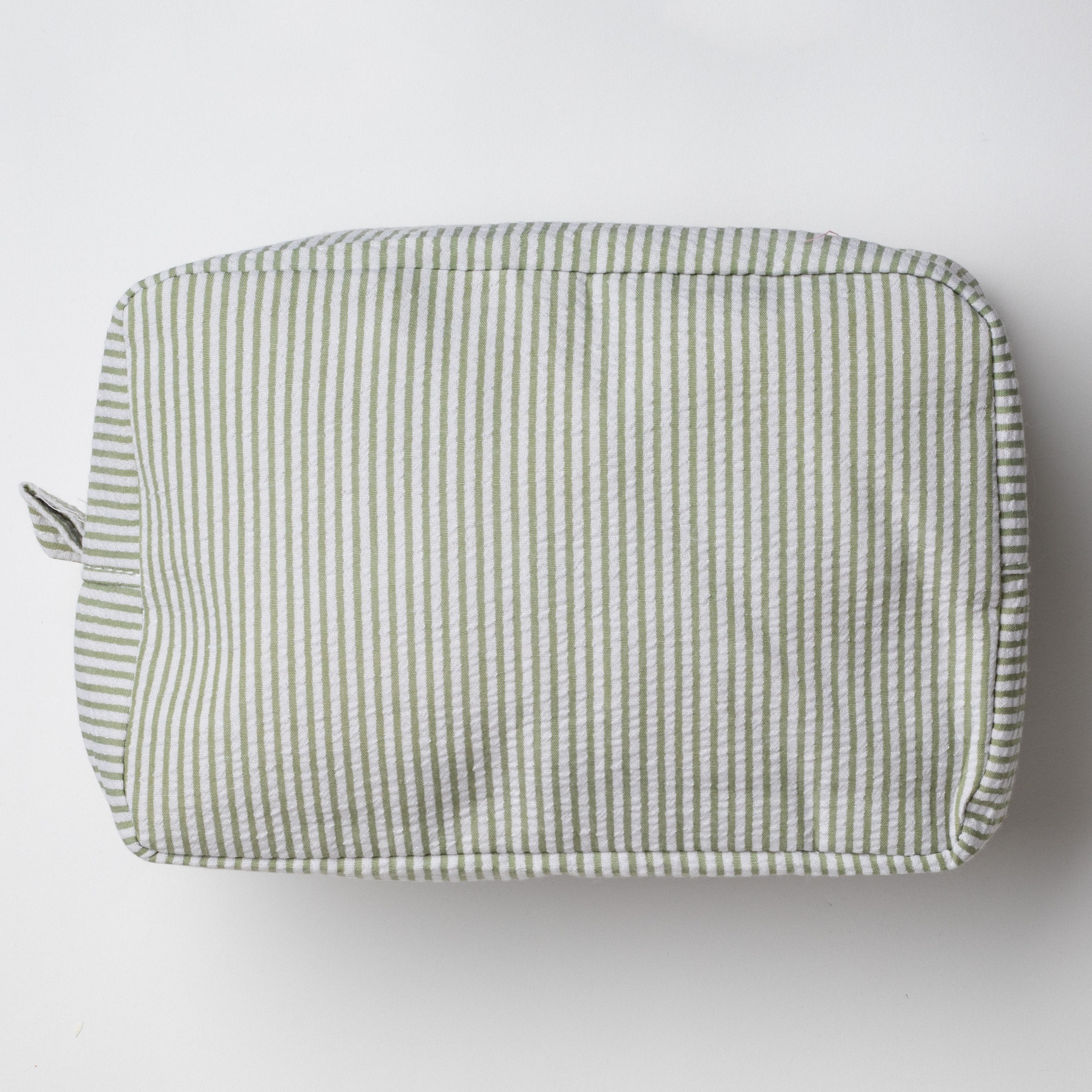 This image shows a rectangular pouch or toiletry bag with a soft, padded structure. It features a light pistachio green and white striped pattern, with a zipper closure visible on one side, along with a small fabric loop near the zipper pull. The pouch is placed on a plain white background.

