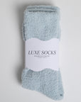 light blue fuzzy socks wrapped in band that says 'LUXE SOCKS'