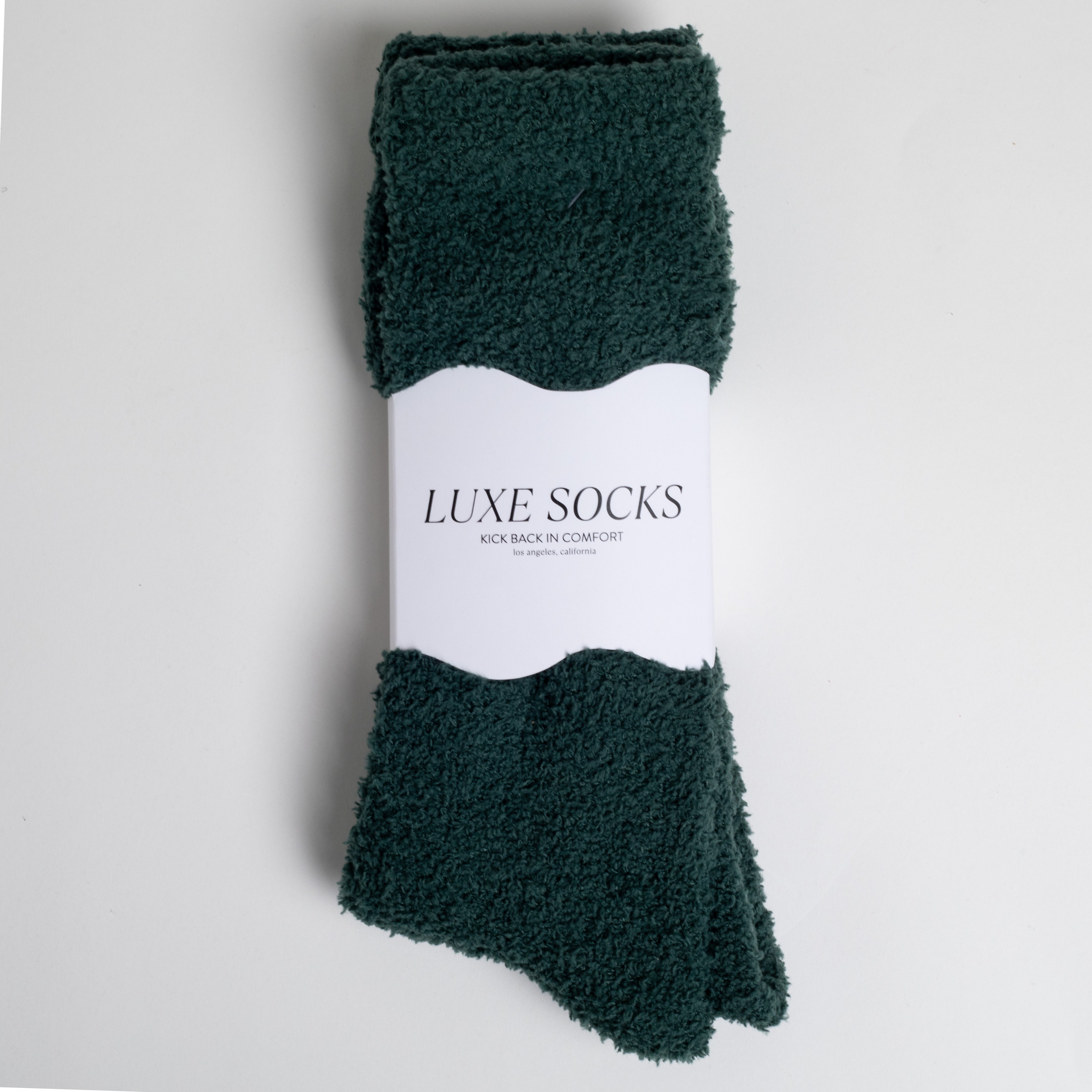 dark green fuzzy socks wrapped in band that says 'LUXE SOCKS'