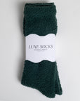 dark green fuzzy socks wrapped in band that says 'LUXE SOCKS'