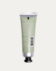 Green hand cream tube with silver cap on a light gray background