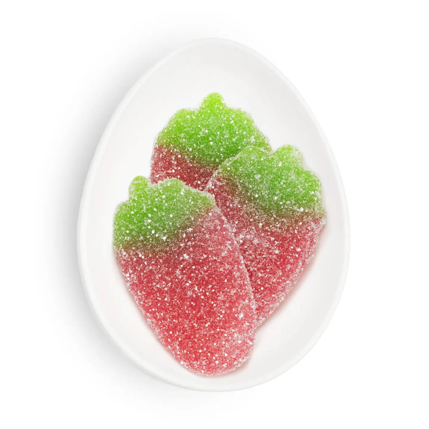 Red and green gummy candy leaves on a white plate