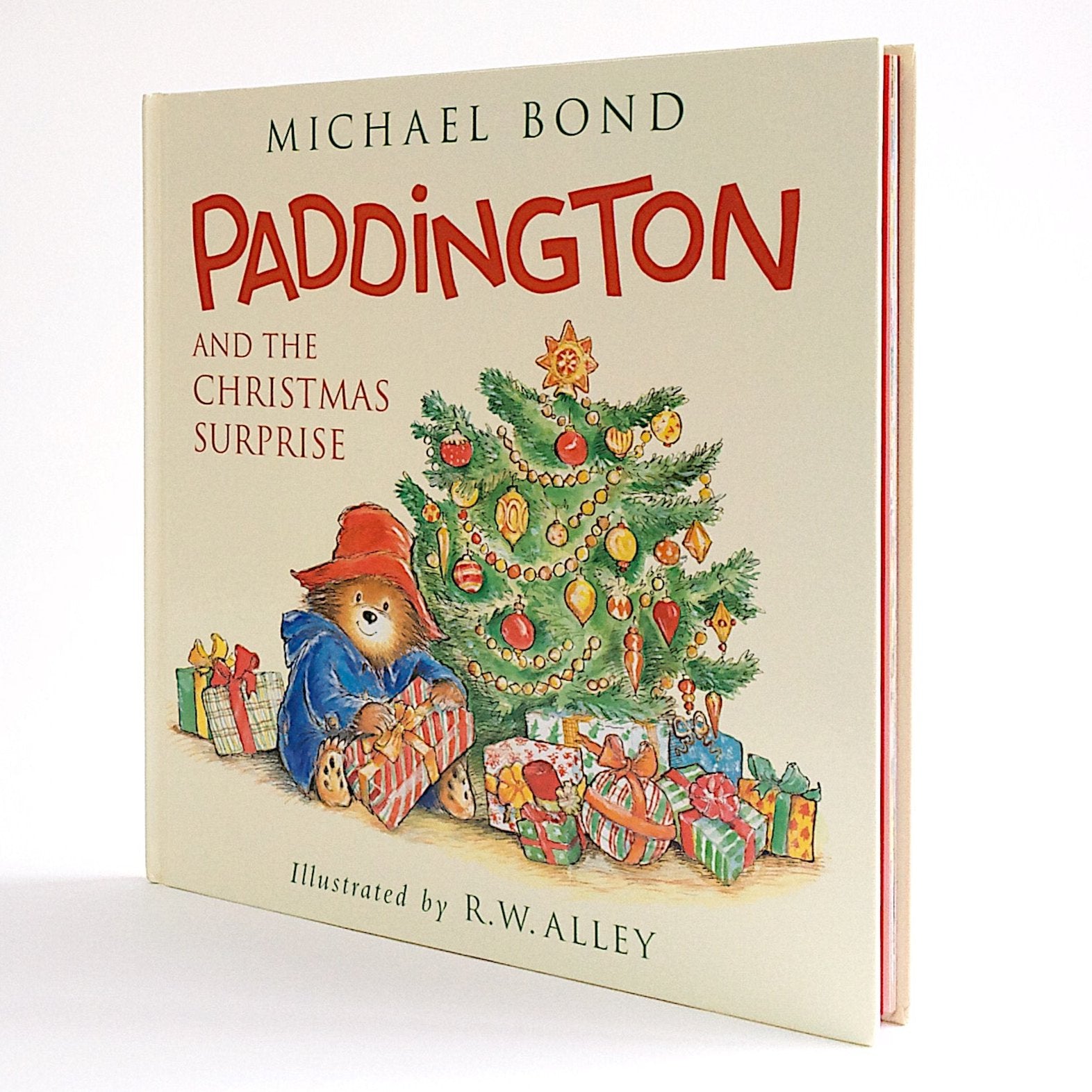 cover of book with paddington bear next to a christmas tree opening presents 