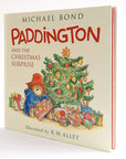 cover of book with paddington bear next to a christmas tree opening presents 