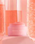 Pink Champagne Beauty Sleep Overnight Lip Mask pot surrounded by sparkling pink champagne in flutes