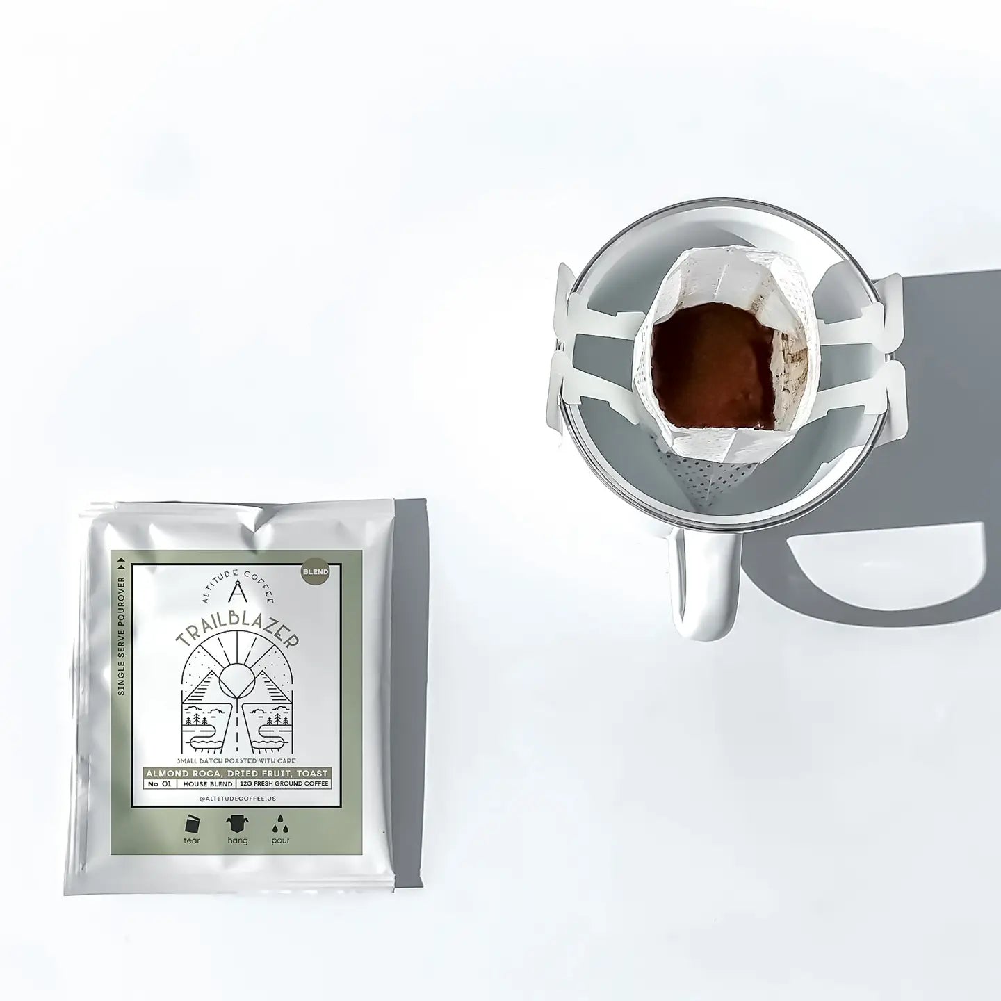 Trailblazer coffee package with a coffee filter and grounds on a white background