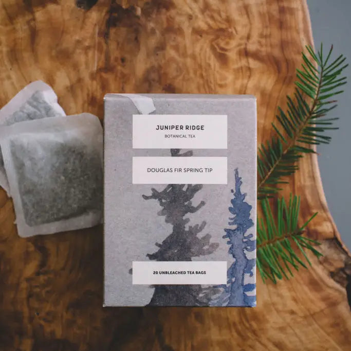 Juniper Ridge tea packaging with tea bags on a wooden surface