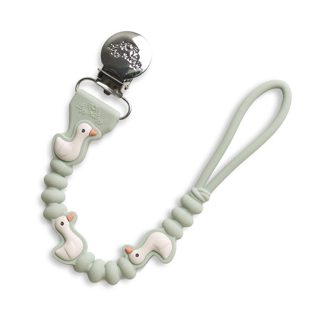 A silicone baby pacifier clip with a mint green beaded strap, featuring three small white duck figures with orange beaks and a silver metal clip.