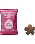A pink bag of Rose Earl Grey Tea Drops next to a single flower-shaped tea drop on a plain white background.