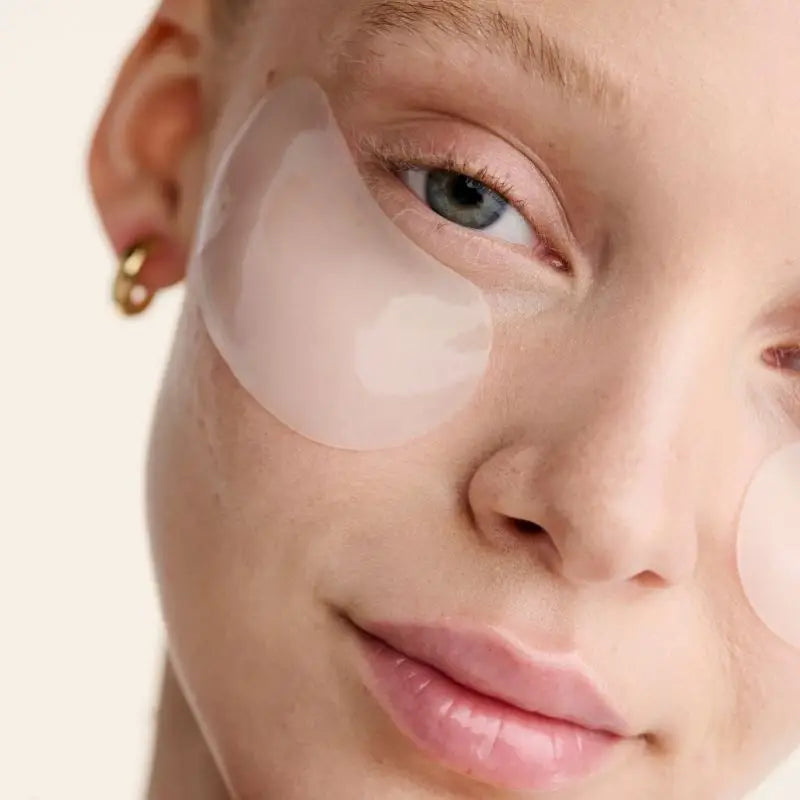 Close-up of a person's face with a patch over one eye against a neutral background