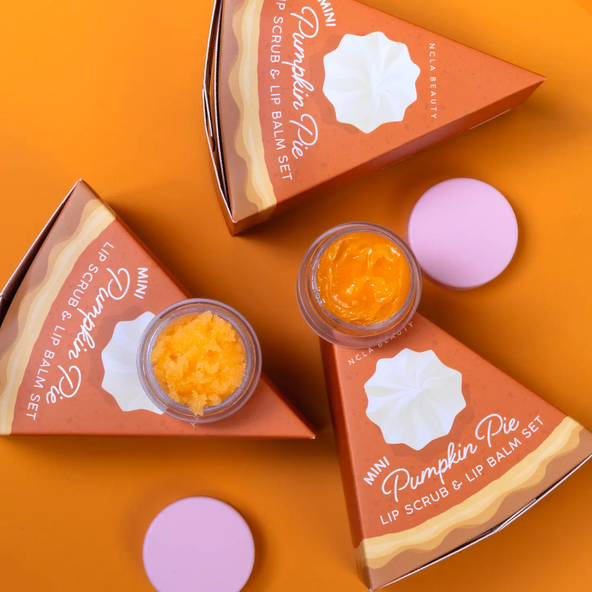 Pumpkin Pie lip scrub and lip balm set on an orange background
