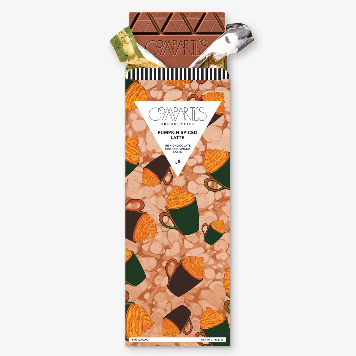 A wrapped chocolate bar from Compáries Chocolates, featuring a pumpkin spice latte pattern with illustrations of coffee cups and pumpkin seeds. The wrapper is partially opened to reveal a pumpkin spice latte chocolate bar and a silver spoon inside.