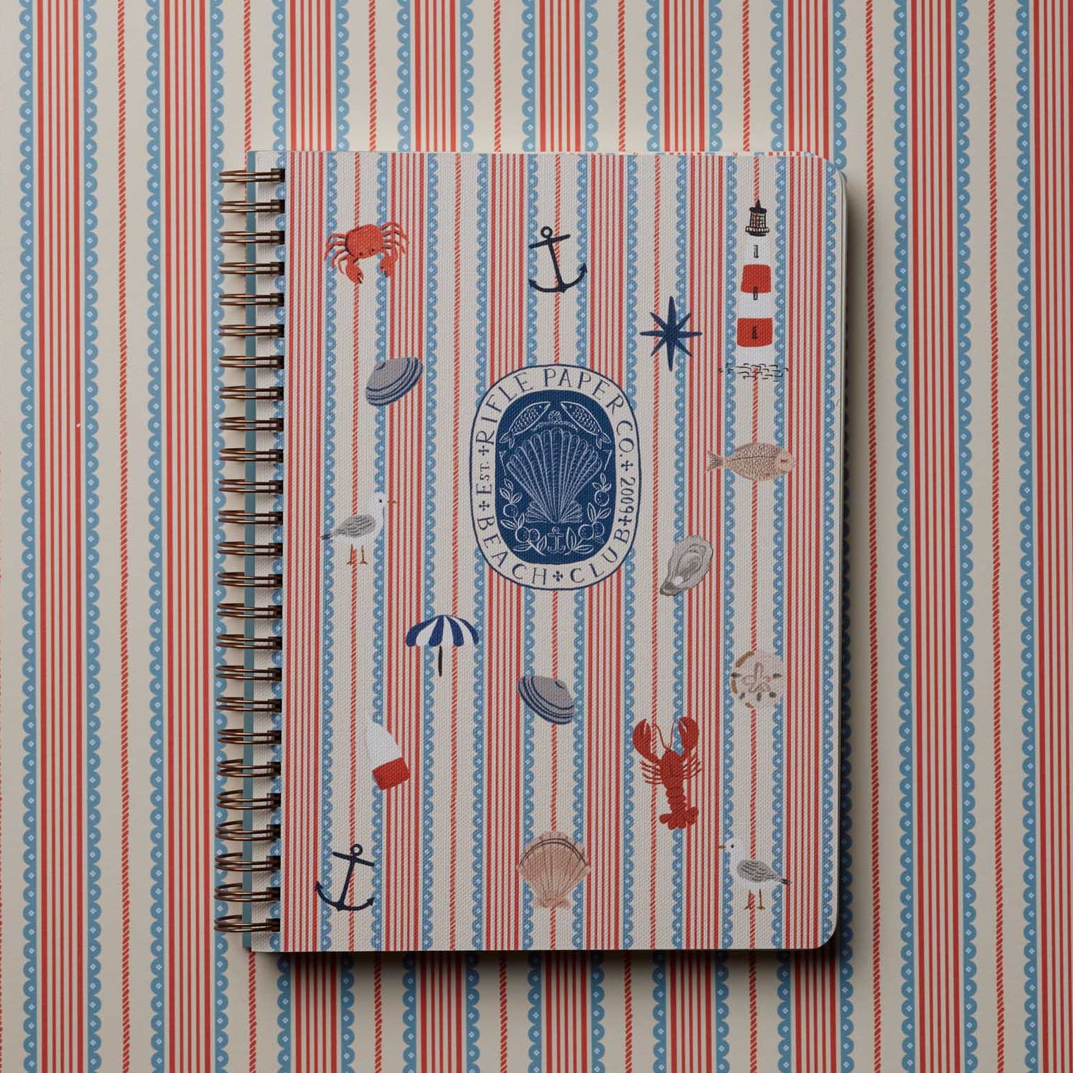 rifle paper co seaside spiral notebook on a striped background