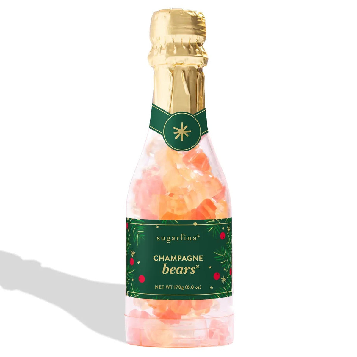 Sugarfina Champagne Bears candy in a clear glass bottle with a gold foil top, green label, and pink-orange candies inside, shown on a white background with a soft shadow.