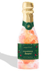 Sugarfina Champagne Bears candy in a clear glass bottle with a gold foil top, green label, and pink-orange candies inside, shown on a white background with a soft shadow.