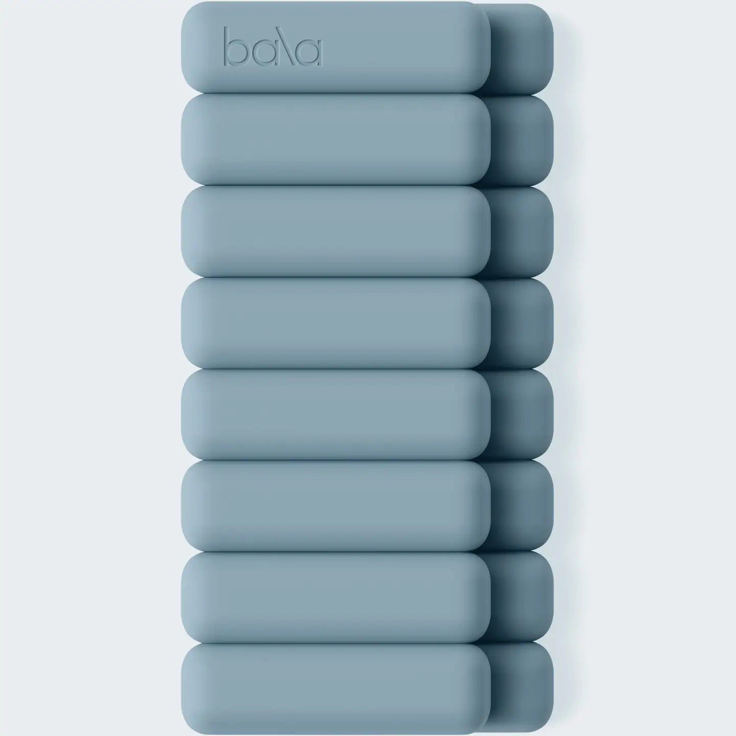 A stack of ten matte blue-gray rectangular bath blocks with rounded corners, arranged vertically on a light gray background. The top block features the debossed brand name 'baha'.